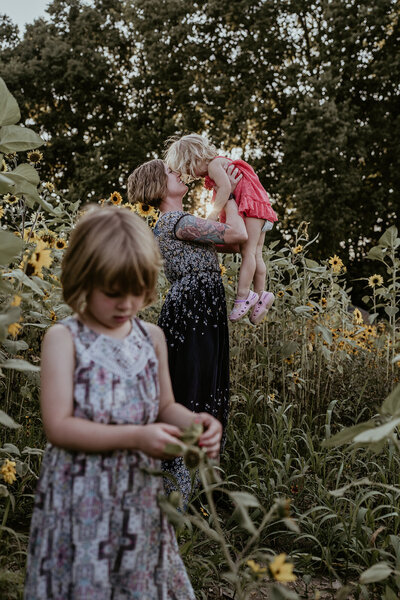 picture of mother and two kids in sunflower field