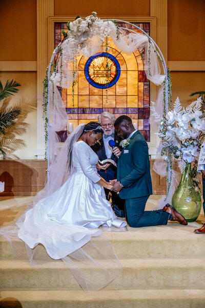 bride and groom kneel at alter for phoenix arizona wedding