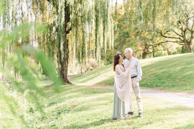 couple posing in front of large willow tree in park in albany ny