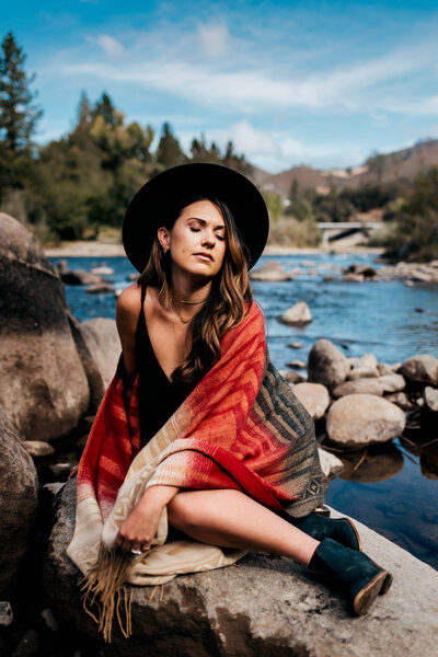 woman basking in the sun sitting on a rock