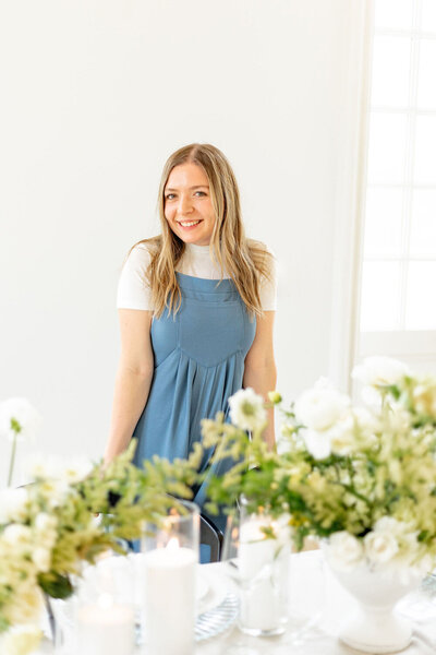 A North Carolina Christian wedding planner posing by her designed tablescape