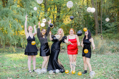 group of 5 girls laying in a circle looking up at the camera and smiling
