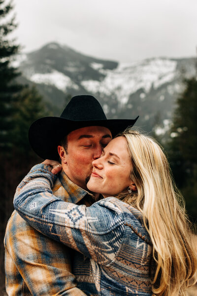 Adventure engagement photoshoot in the snowy mountains with a western vibe