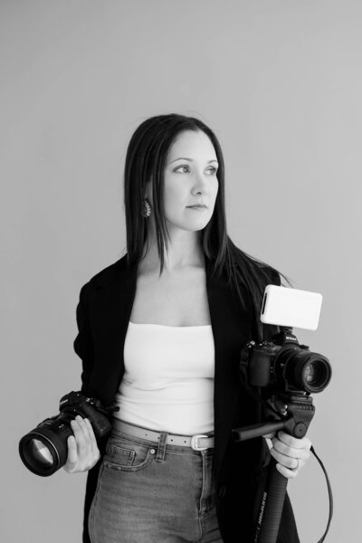 fli-photo-and-video-lead-photographer-and-videographer-holding-their-cameras-and-looking-out-to-their-left