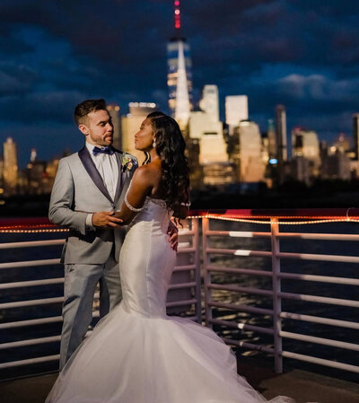A wedding day night shot of the bride and groom in front of the NYC skyline