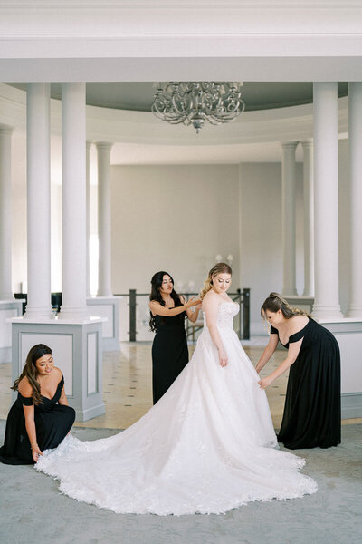 Bride getting ready with bridesmaids in black dresses before Ontario wedding ceremony at Deer Creek
