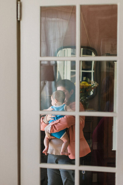 Mother holding baby by window indoors
