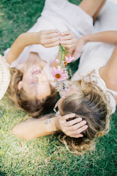 Film image of mom putting flower in little girl's hair in a garden by Richmond VA family photographer