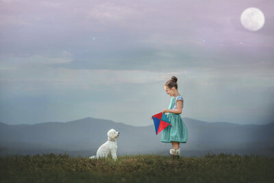 "Outdoor photo – girl flying kite with pup in field, capturing childhood joy"