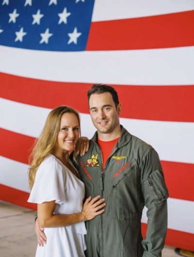 military couple posed in front of american flag