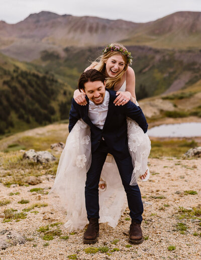 couple gives a piggyback ride during their elopement in Aspen, Colorado with Alpine Vows