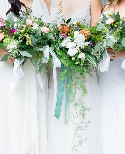 close-up of bride and braidsmaids bouquets all wearing white