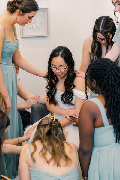 Bridesmaids praying over the bride at her North Carolina Wedding