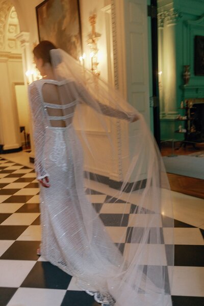 Bride walking in the Swan House holding her veil Photography Michelle Scott