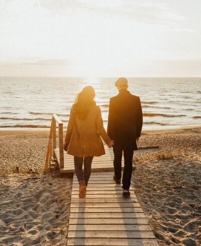 Couple walking into the sunset hand in hand can represent a happy couple who was able to restore the broken trust recovering from an affair. Couples in the aftermath of infidelity can benefit from affair recovery coaching by Relationship Experts in the USA, Canada, and worldwide. apply for a free consultation today!