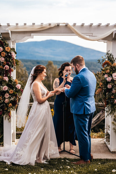 Couple exchanging rings in front of arbor and mountain view at Cobb Hill Estate by Lisa Smith Photography