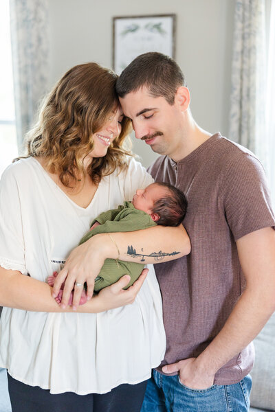 mom and dad standing holding their newborn baby