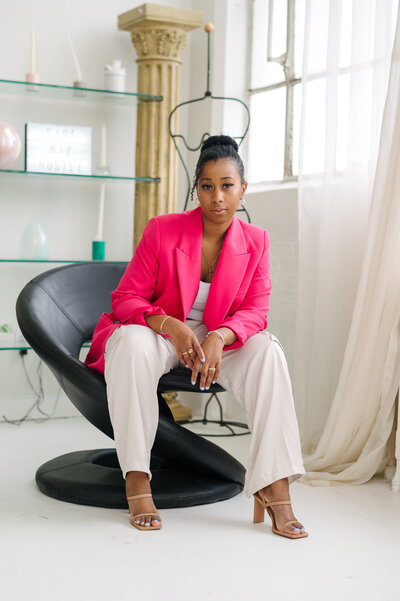 Women wearing bright pink blazer in a studio sitting