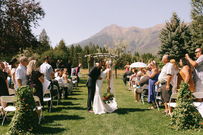bride and groom kissing at the end of the aisle