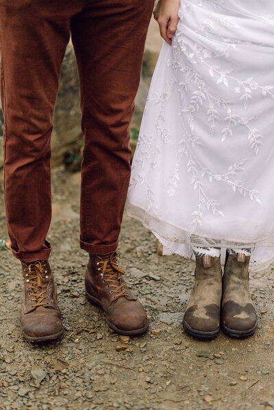 Cinematic wide shot of the couple embracing on the summit, with soft focus and natural light.
