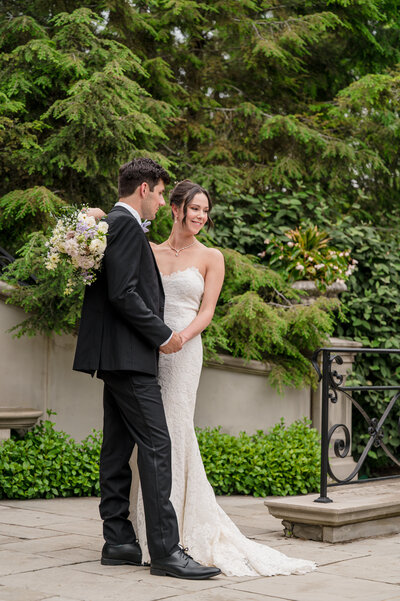 Bride and groom sitting together, holding hands on their wedding day, sharing a quiet and intimate moment in Columbus, OH.