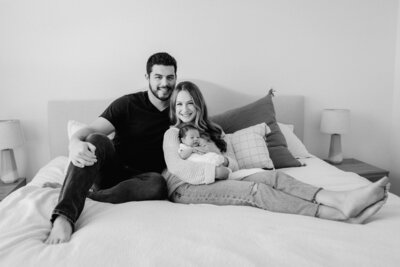 Newborn photography family photo woman with husband baby on bed in Tampa Bay, Florida Nadine B Photography