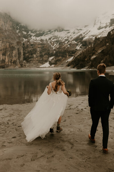 couple walking towards Oeschinensee Lake during their elopement in Switzerland
