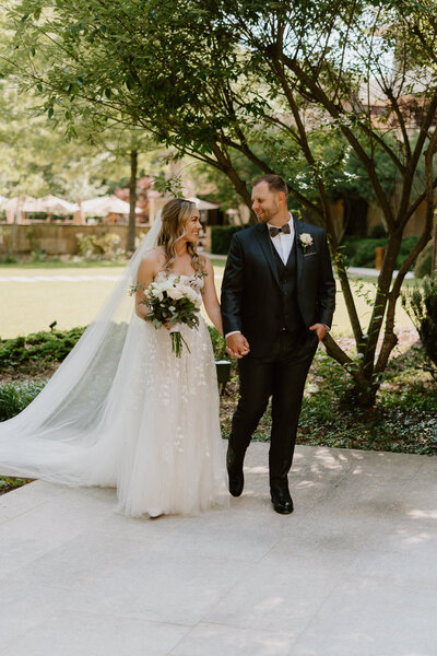 Bride and groom holding hands while strolling