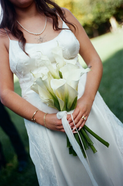 woman's hand with engagement ring touching her dress