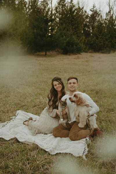 Couple with a cocker spaniel dog and a siamese cat