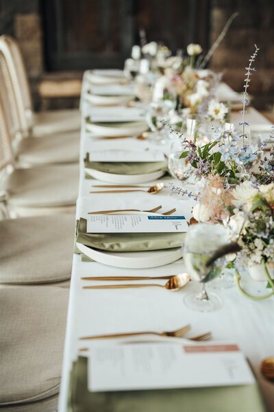 Long, simply styled wedding reception table set for dinner with an elegant, minimal aesthetic.