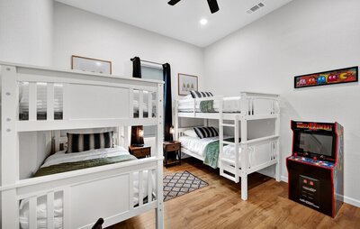 Bedroom with two sets of bunk beds, sleeping four in this three-bedroom, two-bathroom home with fully stocked kitchen, large backyard, grill, and basketball hoop in downtown Waco, TX.