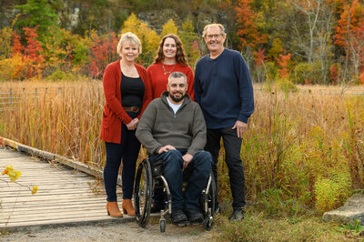 Mom and dad with adult children, one in a wheelchair for their fall family photos in Burlington, Ontario.