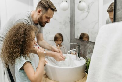 Rodič s dětmi při čištění zubů – správné návyky od dětství