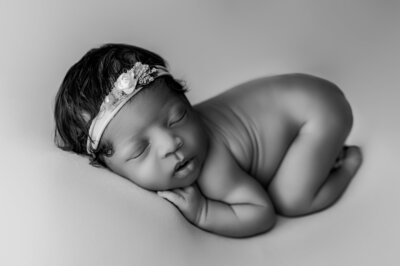 Newborn girl sleeping curled up