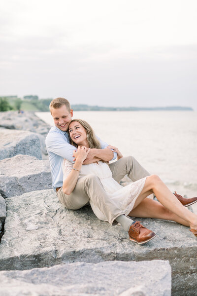 Bride and groom laughing together at an engagement session by Lake Michigan