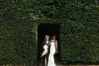 Bride and groom in greenery archway at Killruddery House and Gardens, Wicklow