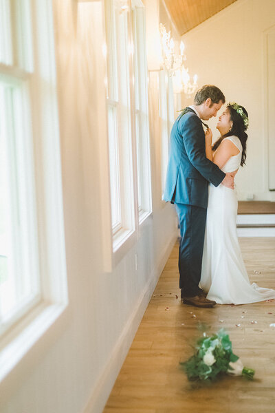 Couple slow dance inside a charming yellow chapel with the bouquet on the floor