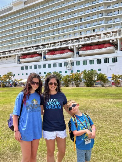 Sonia and her kids standing near a cruise ship