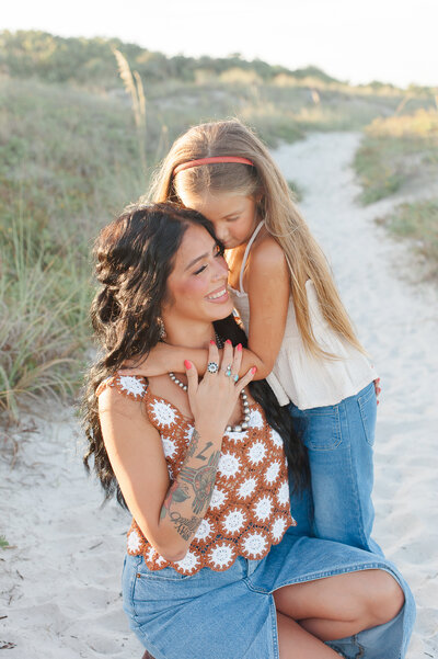 Mother and daughter hugging lovingly on the beach during their family photo session with a Central Florida photographer