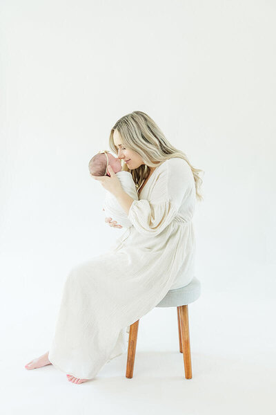 mom holding newborn baby girl in studio photos