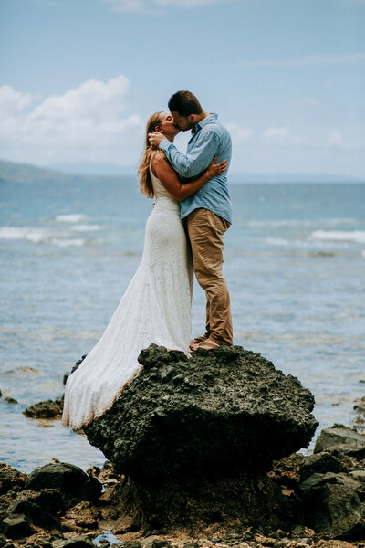 bride and groom on a rock