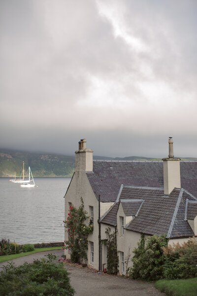 A cottage in Scotland sits near the edge of a lake. Deborah Zoe.