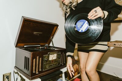 about page image with brandy boyett holding a vinyl record to place on the player nearby