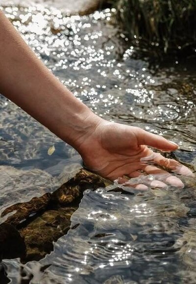 Close-up of hand in water, evoking clarity, softness, and somatic connection