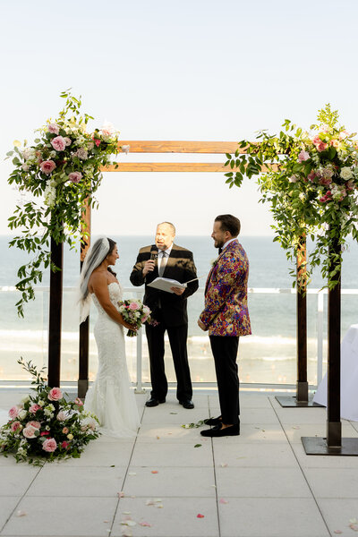Close-up of exquisite floral arrangements by Leigh Florist with pastel roses, hydrangeas, and eucalyptus accentuating a stunning wedding venue.