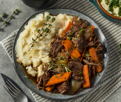 Slice of avocado toast topped with a sunny-side-up egg on a white plate, representing balanced, nutrient-dense breakfast options.