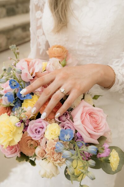 Bride with her bridesmaids holding light pink light peach and blue wedding party flowers