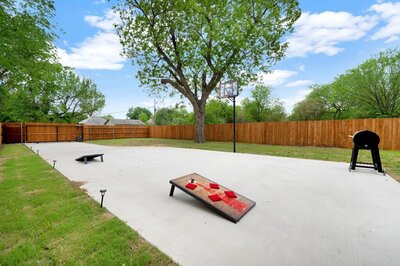 Fenced in yard with basketball hoop and pellet grill at this three-bedroom, two-bathroom home with fully stocked kitchen, large backyard, grill, and basketball hoop in downtown Waco, TX.