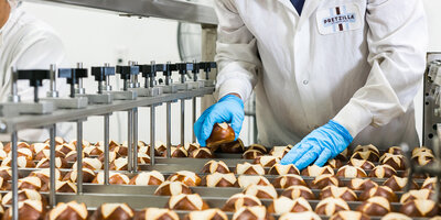 wellness and fitness coach sitting on concrete stairs outdoors, wearing baby blue yoga pants and a white sports crop top